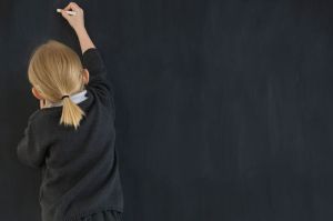 schoolgirl-writing-on-a-chalkboard-pic-getty-39007562
